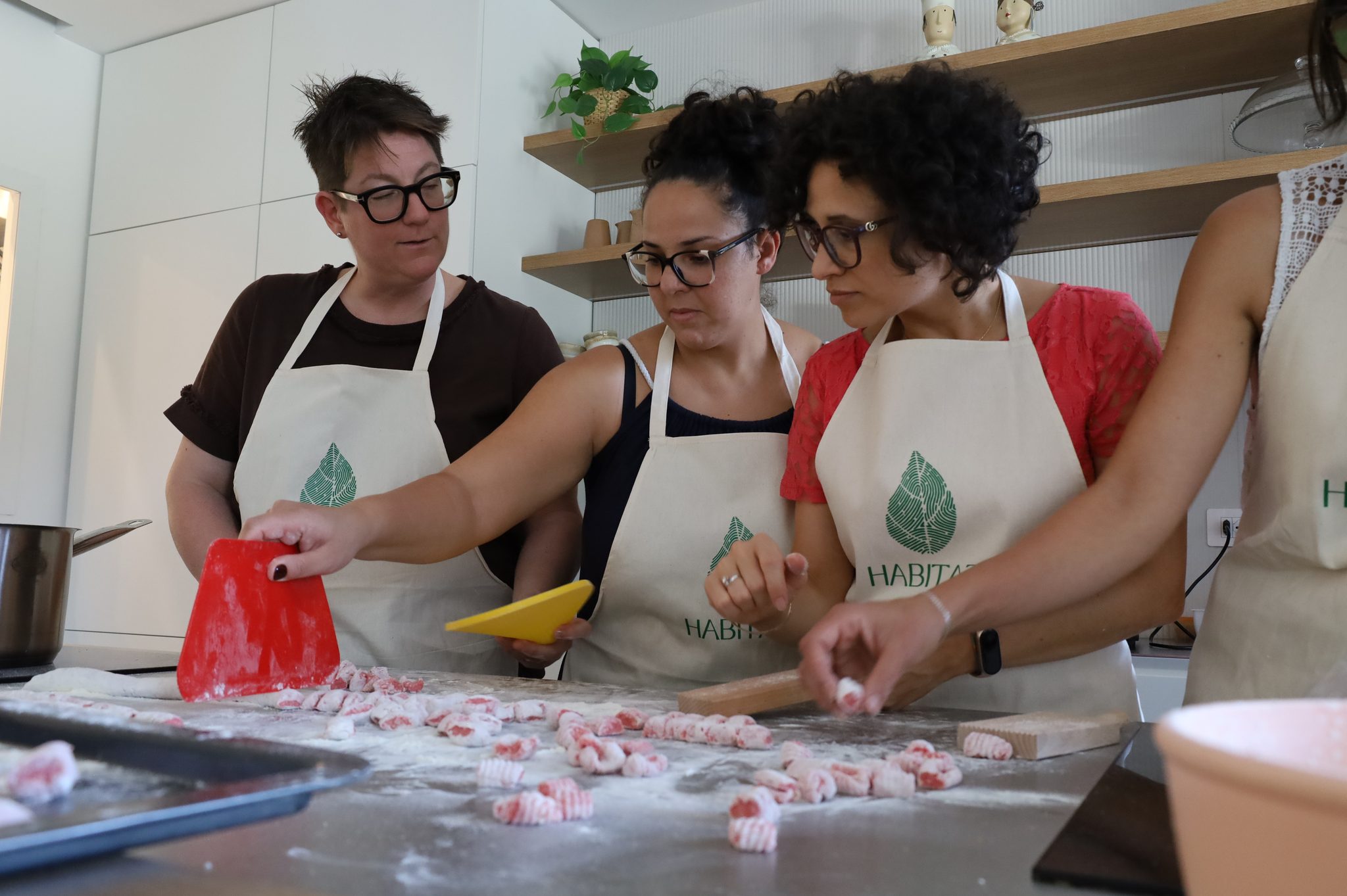 Partecipanti formano gnocchetti di pasta fresca colorata al banco